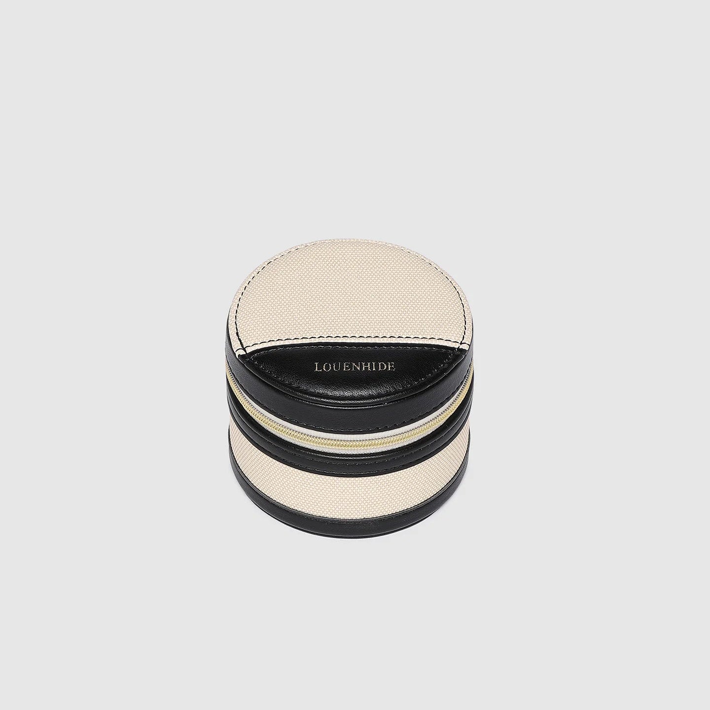 Round jewelry box with black and beige design on a light gray background