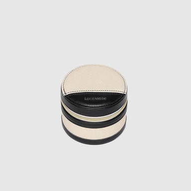 Round jewelry box with black and beige design on a light gray background